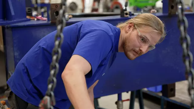 Voith Service: Patrick Schulte inspiziert ein Gerät, das mit Ketten an einem Kran befestigt ist